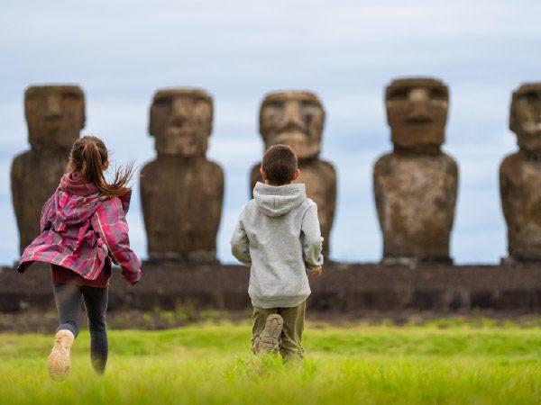 Kids running in Rapa Nui, with Moais in the background