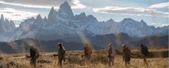 Group of hikers walking through Patagonian plains with Mount Fitz Roy rising in the background