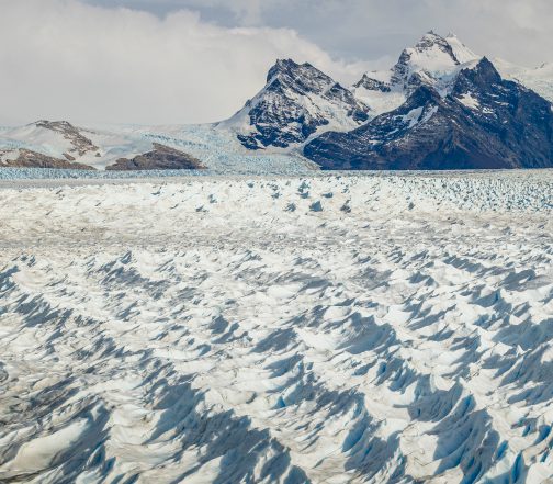 Vast expanse of the Perito Moreno Glacier with jagged blue-white ice formations and mountain backdrop near El Calafate, Argentine Patagonia