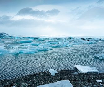 Floating icebergs and glacial ice on Jökulsárlón Glacier Lagoon, Iceland, under a dramatic Winter sky